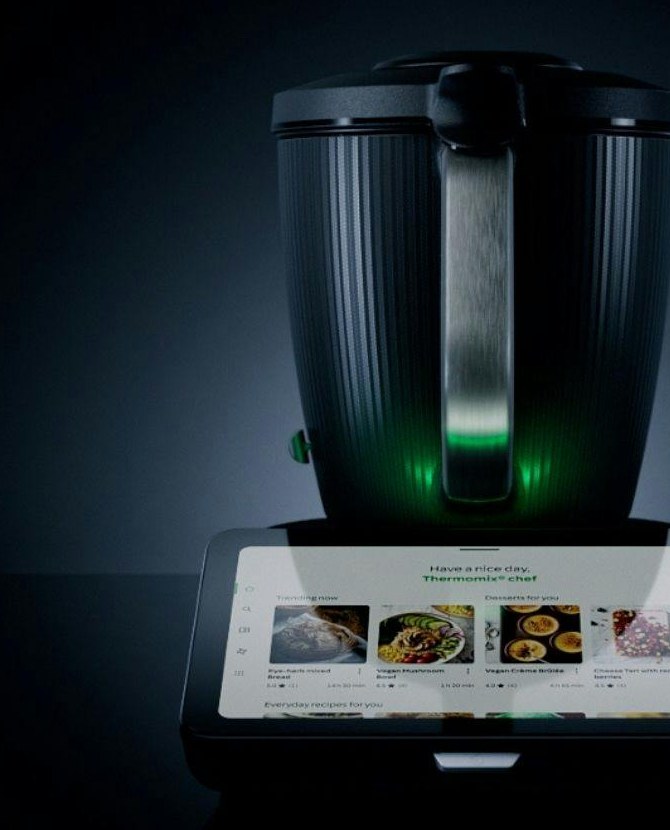 Thermomix TM7 with glowing green status light and the integrated touchscreen displaying recipes