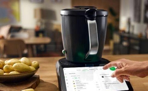 Thermomix TM7 on a kitchen counter with the touchscreen guiding a recipe
